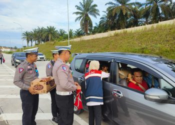 Kasat Lantas Polres Siak Bagikan Air Mineral dan Roti Untuk Pemudik Di Tol Permai