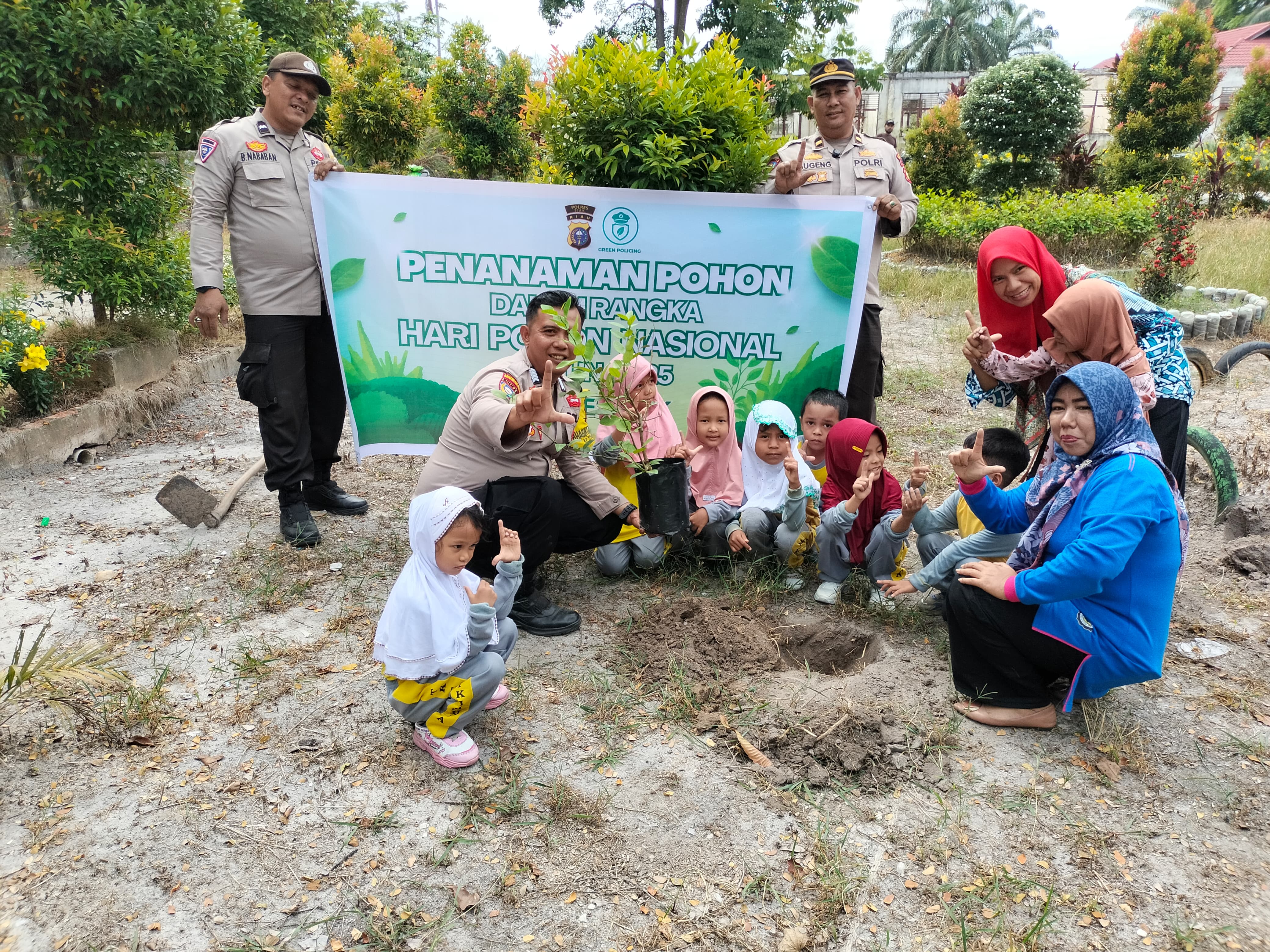 Green Policing Polsek Tualang: Tanam Bibit Jeruk dan Matoa Bersama TK Cendikia Muda di Sekolah